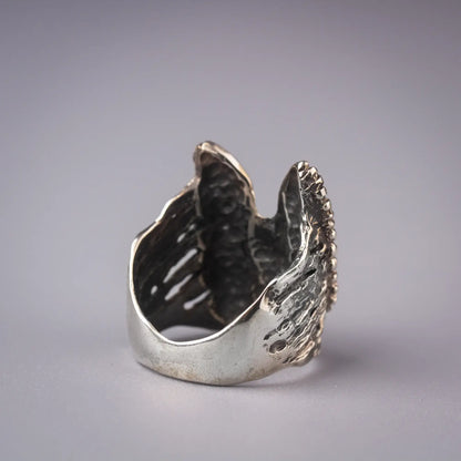 Sterling silver statement ring with abstract winged design, symbolizing a guardian angel, artistic and spiritual jewelry piece.