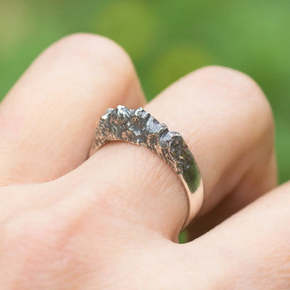 Sterling silver mountain range ring with textured rock style design on a woman's finger