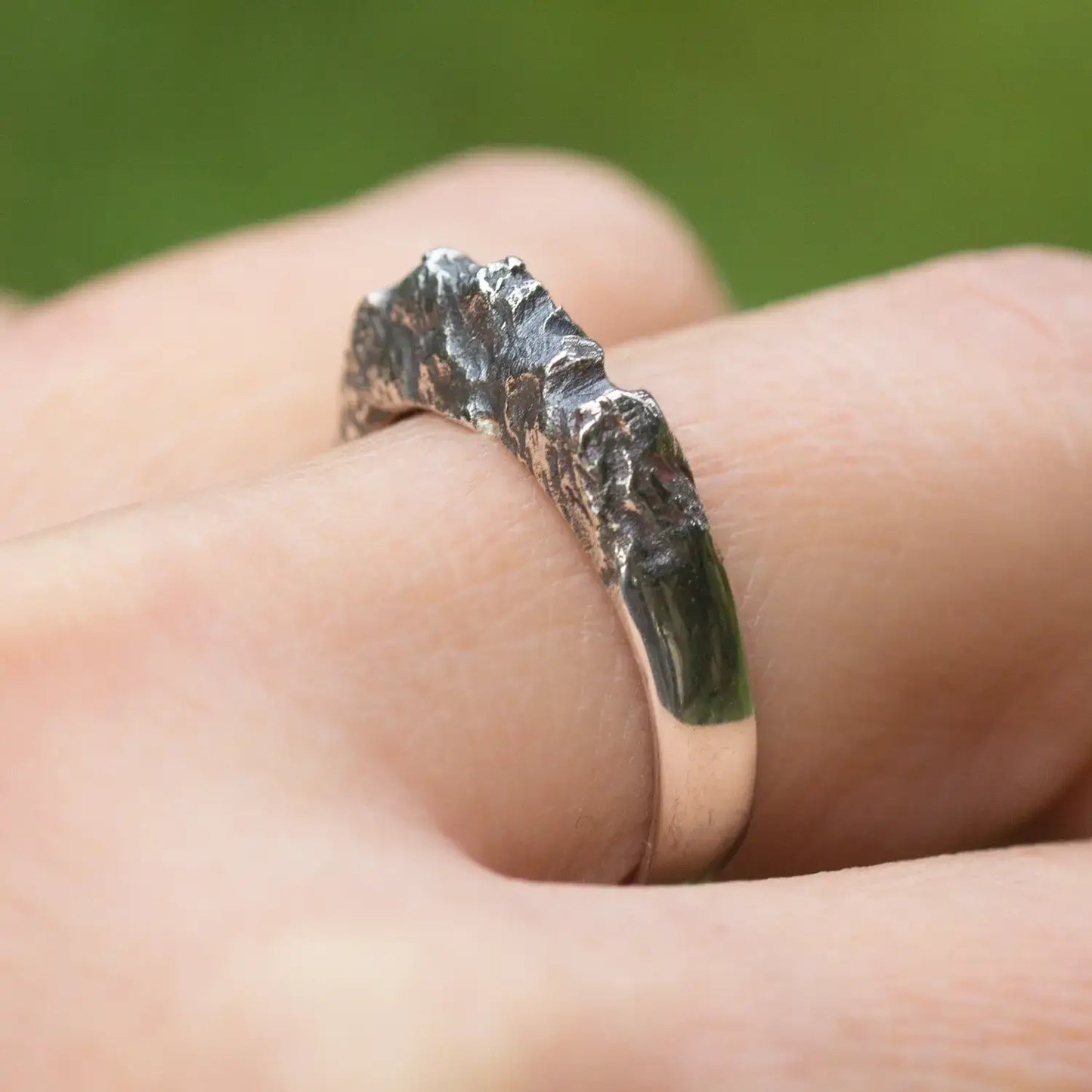 Sterling silver mountain range ring with textured rock design on finger, showcasing a nature-inspired organic style for women.