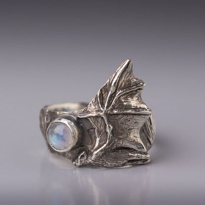 Sterling silver bat ring with a moonstone gemstone and detailed flying bat wings design.