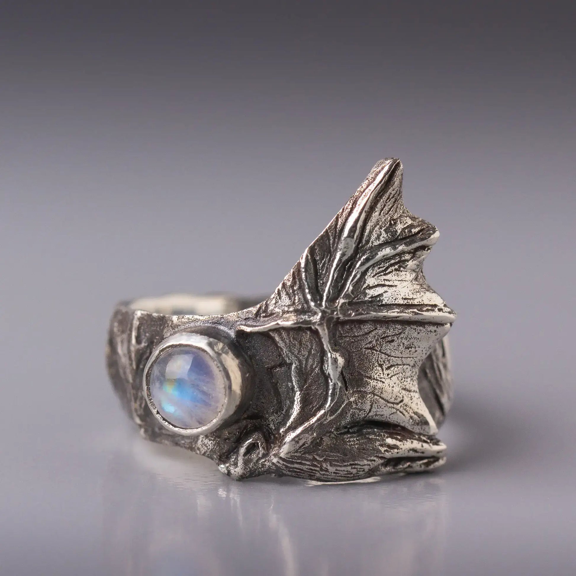 Sterling silver bat ring with detailed bat wings and moonstone gemstone, featuring gothic and nature-inspired design elements.