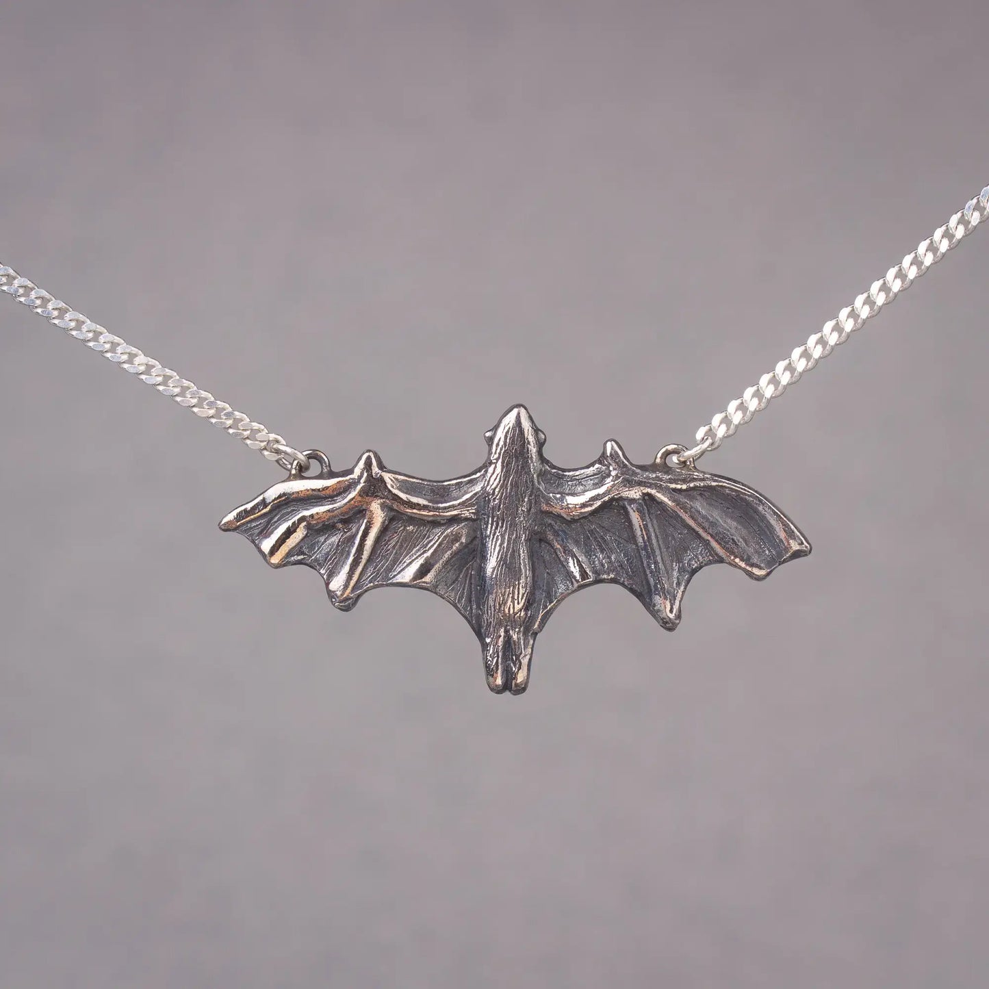 Silver bat pendant necklace featuring a large flying fruit bat, perfect statement piece for bat lovers and Halloween jewelry enthusiasts.