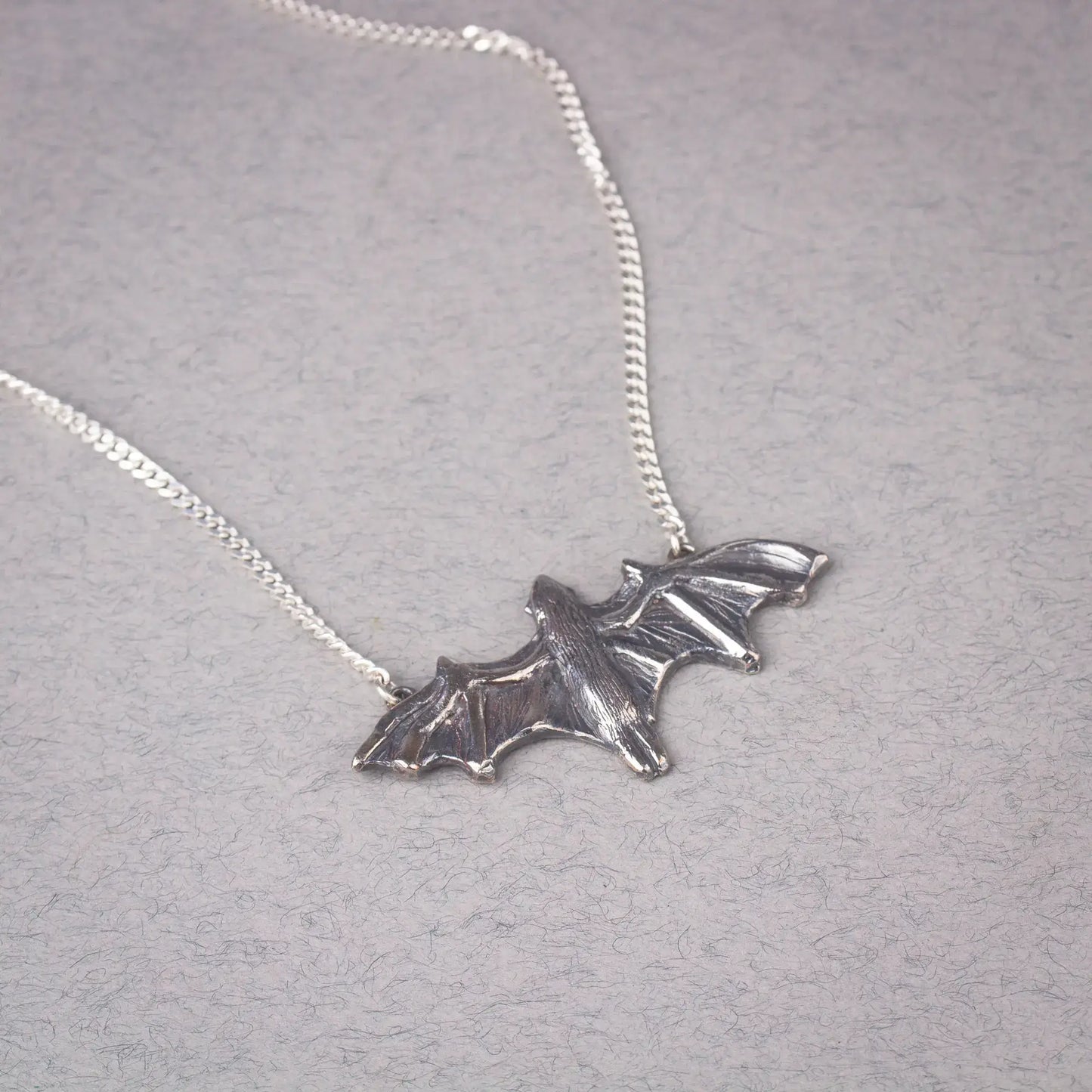 Sterling silver bat pendant necklace featuring a large flying bat design, perfect statement piece for Halloween and bat enthusiasts.