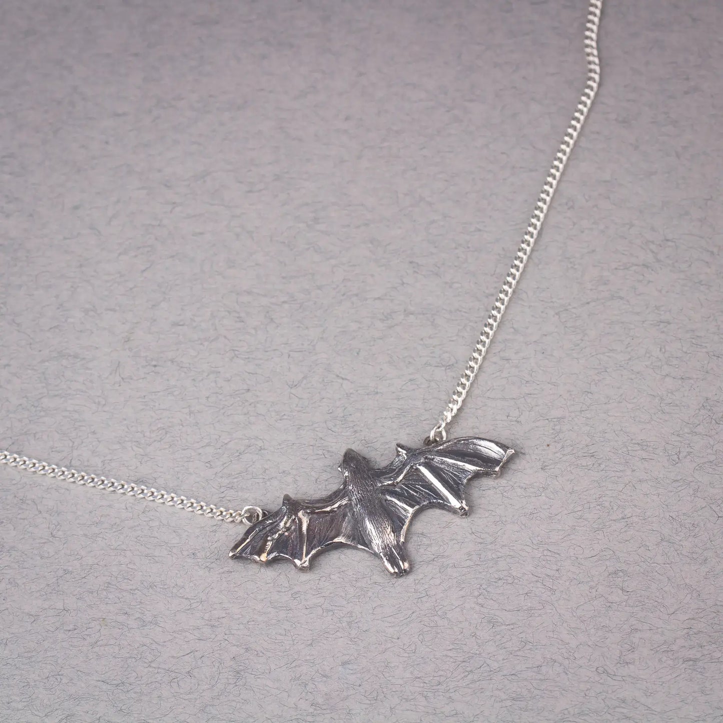 Sterling silver bat pendant necklace featuring a large flying fruit bat design, perfect as a statement piece for bat lovers and Halloween events.