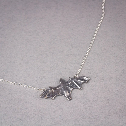 Sterling silver bat pendant necklace featuring a large flying fruit bat design, perfect as a statement piece for bat lovers and Halloween events.