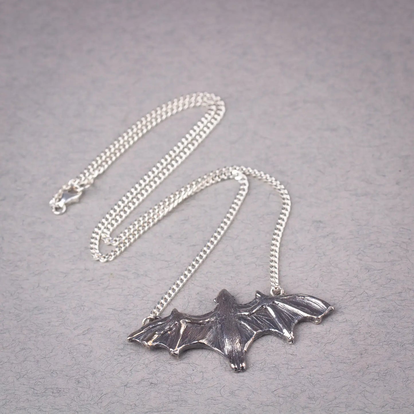 Sterling silver bat pendant necklace featuring a large flying fruit bat design, perfect for a statement piece or Halloween accessory.