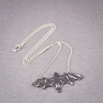 Sterling silver bat pendant necklace featuring a large flying fruit bat design, perfect for a statement piece or Halloween accessory.