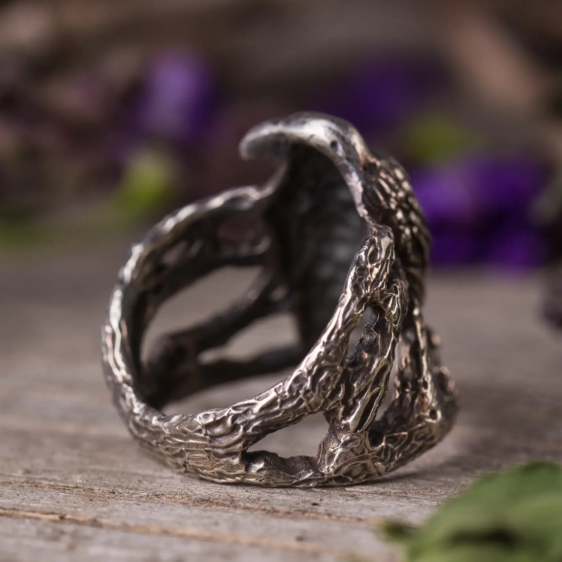 Handcrafted silver crow ring with intricate twig design, symbolizing mystery and nature's beauty.