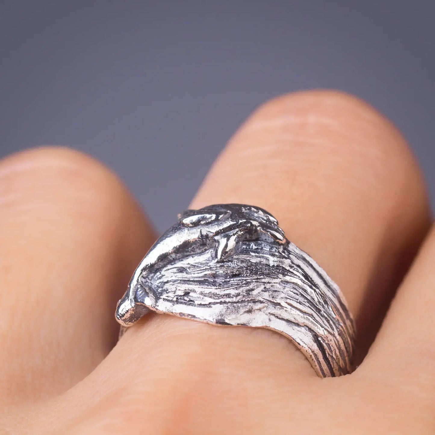 Sterling silver dolphin ring with lifelike design on a wide wavy band, ideal ocean-inspired jewelry for sea life enthusiasts.