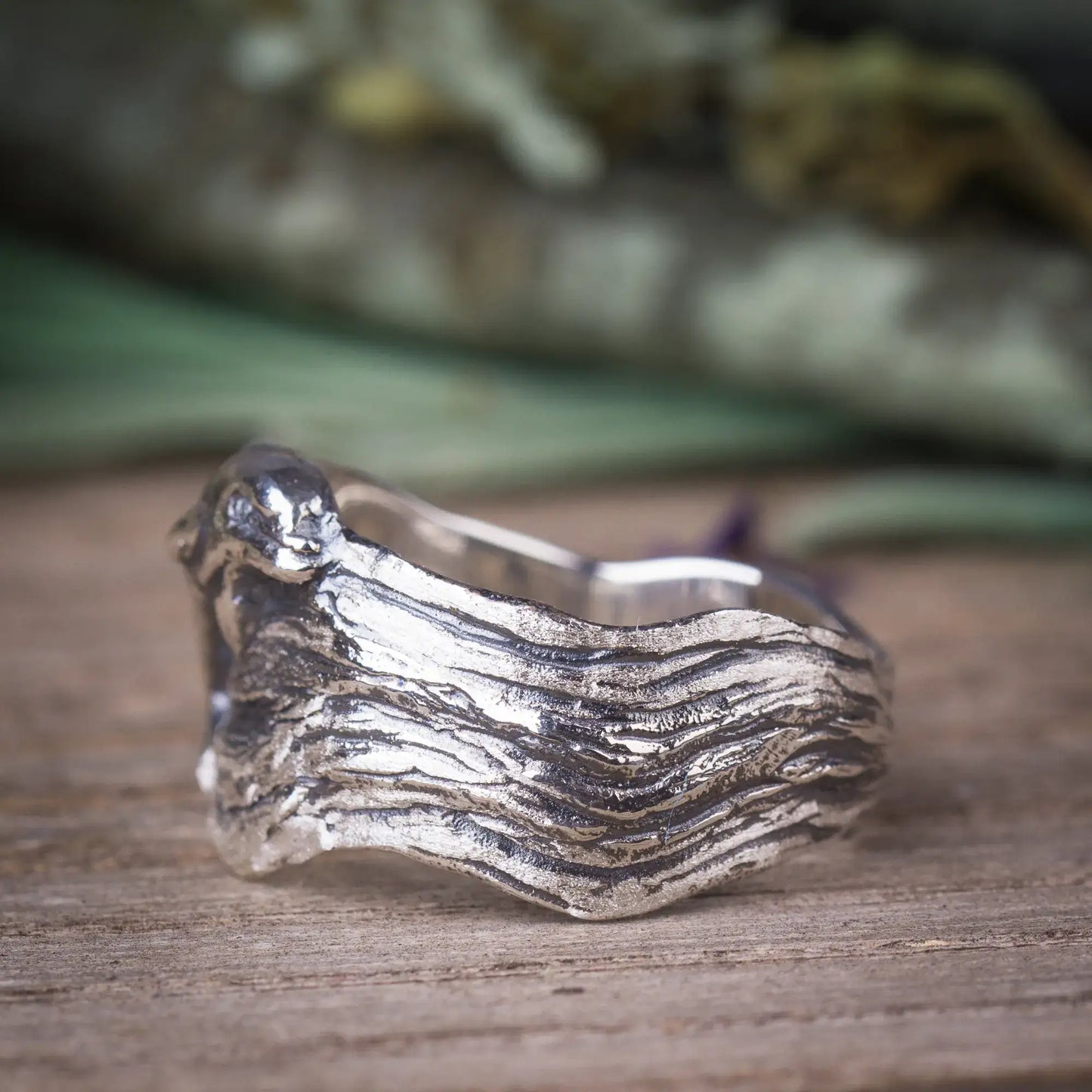 Sterling silver dolphin ring with wide, wavy band, showcasing ocean-inspired design and lifelike dolphin detail.