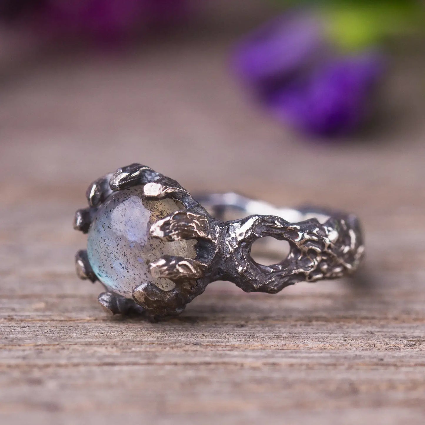 Labradorite twig ring in sterling silver with rough cut gemstone, green witch style, magical forest-inspired jewelry on wooden surface.