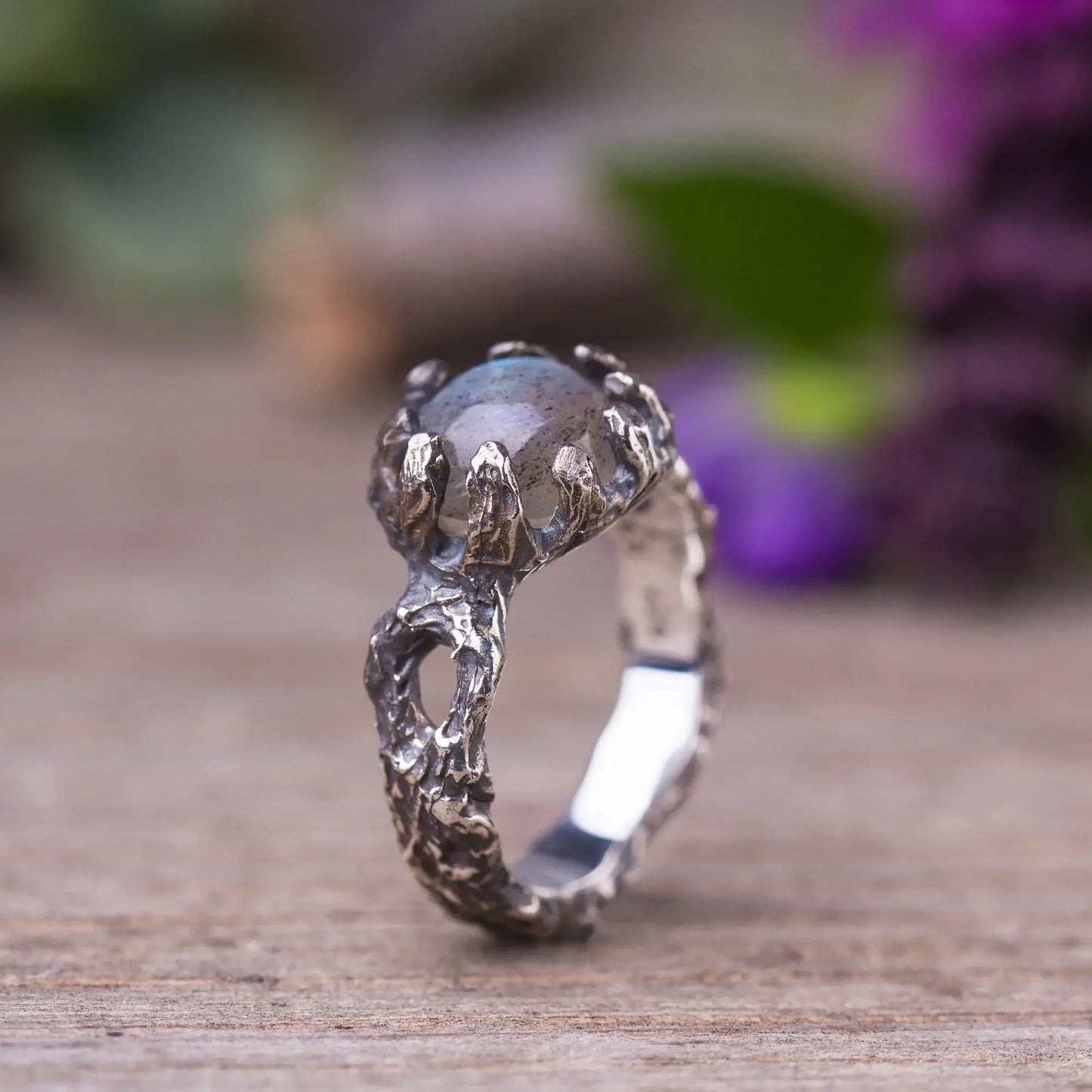 Handcrafted labradorite twig ring in sterling silver with green witch style on wooden surface, magical forest-inspired jewelry.