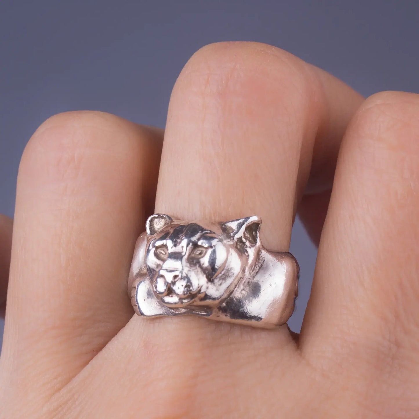 Sterling silver mountain lion cougar ring on finger, handcrafted spirit animal wildlife jewelry symbolizing strength and courage.