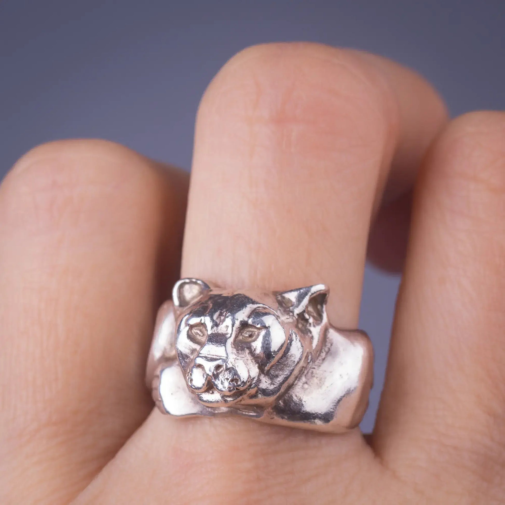 Sterling silver handcrafted mountain lion cougar ring symbolizing strength and courage on finger.