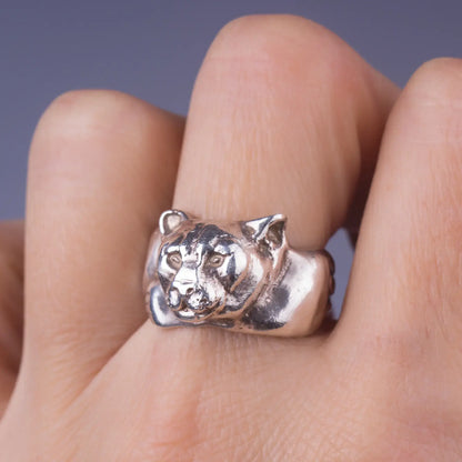 Handcrafted sterling silver mountain lion cougar ring, symbolizing strength and courage, worn on a finger.