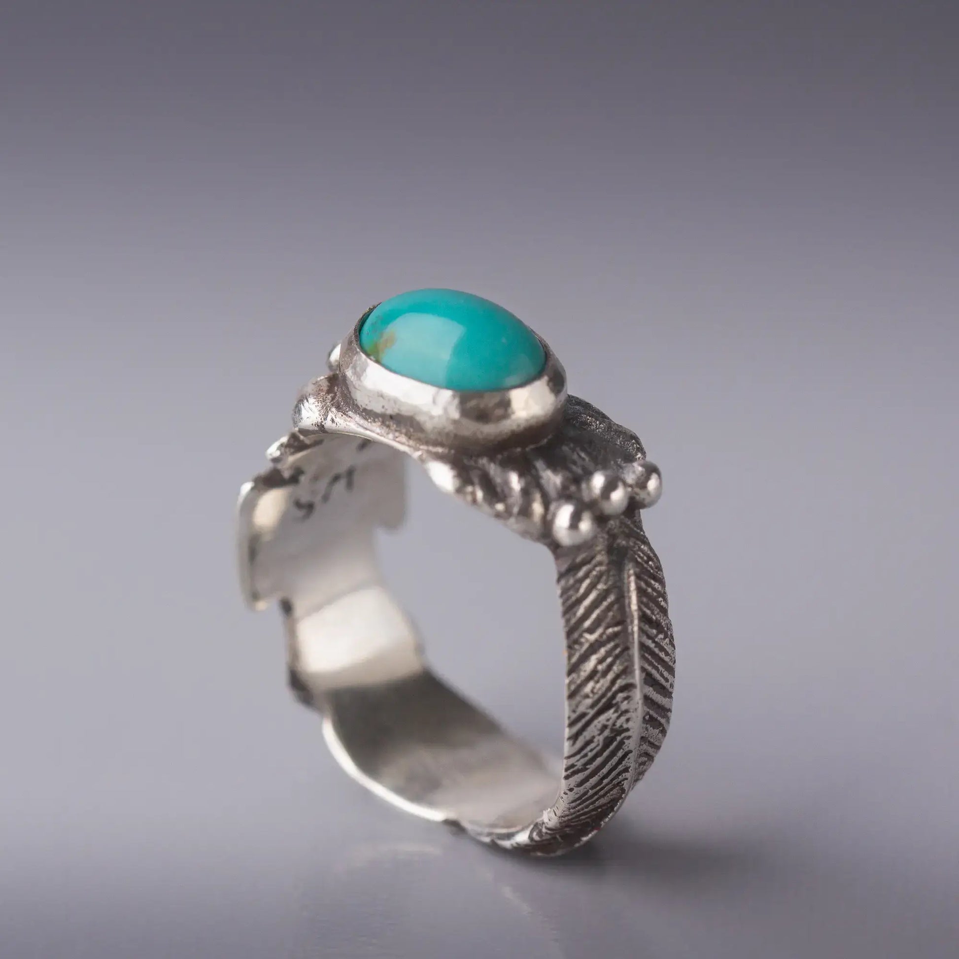 Sterling silver Thunderbird ring with turquoise oval gemstone and feather design, capturing Southwestern spirit and craftsmanship.