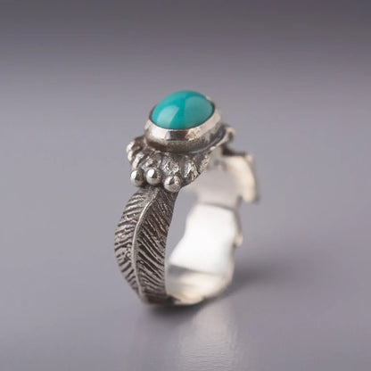 Thunderbird ring with turquoise oval gemstone and sterling silver feather design, capturing Southwestern power and grace