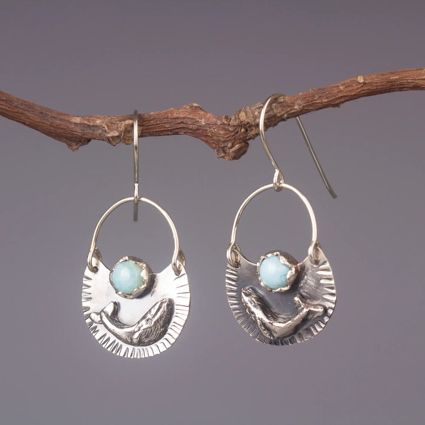 Humpback whale dangle earrings in silver with Larimar gemstone, ocean-style earrings on rustic branch display