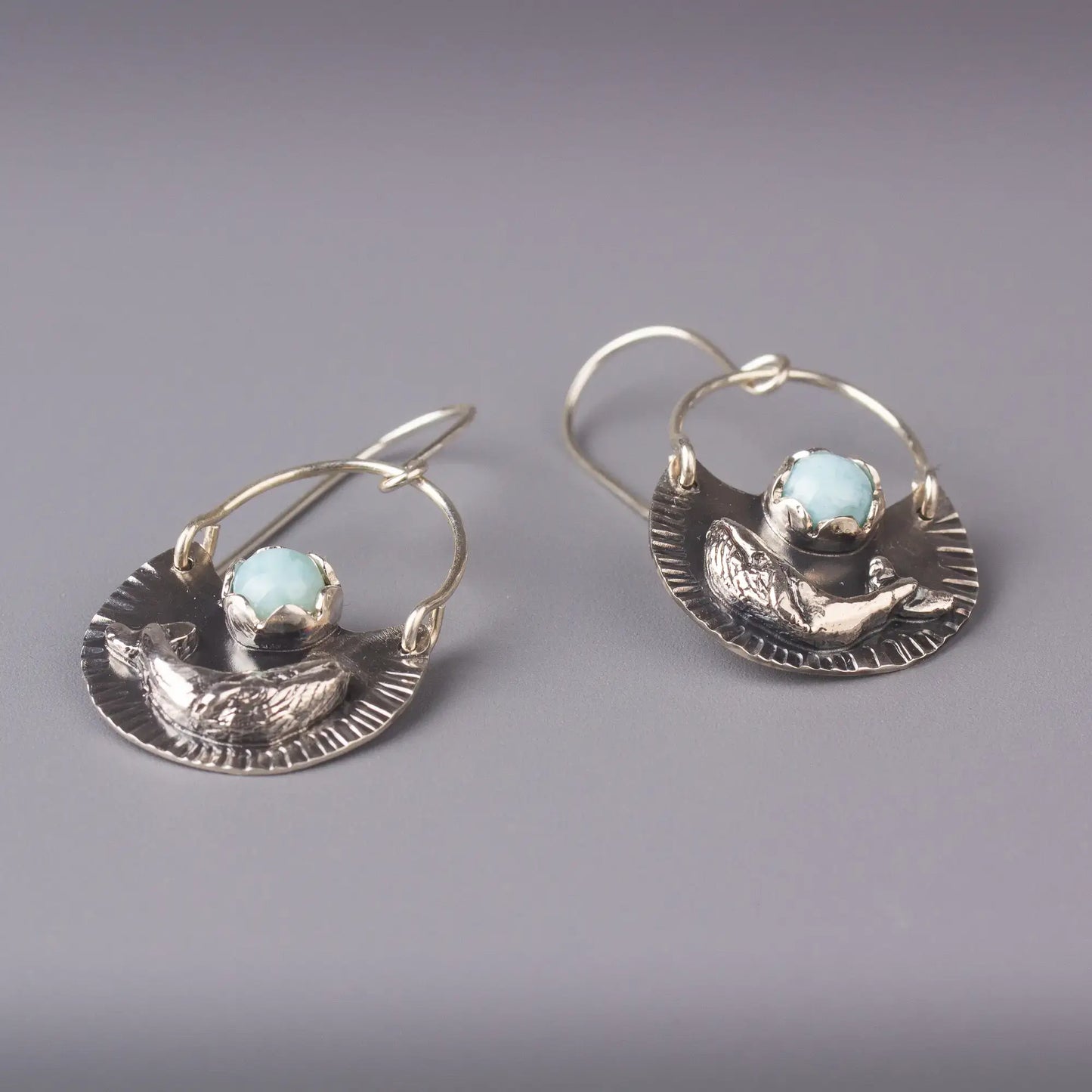 Silver humpback whale dangle earrings with Larimar gemstones, showcasing ocean-inspired elegance and handcrafted detail.