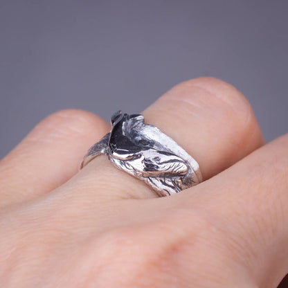 Detailed humpback whale ring in sterling silver on finger, showcasing ocean-inspired statement jewelry with wide band design.