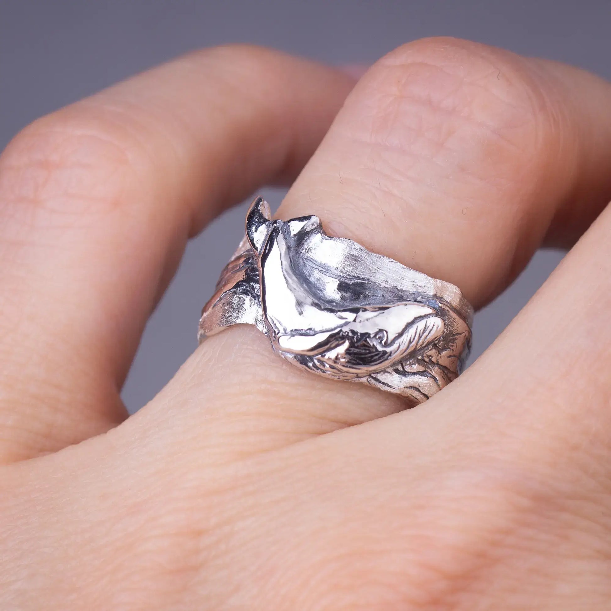 Whale ring in sterling silver featuring a detailed humpback whale design on a wide band, worn on a finger.